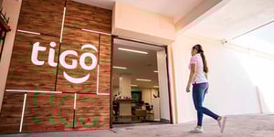 Mujer ingresando a una sucursal de la empresa Tigo en Guatemala